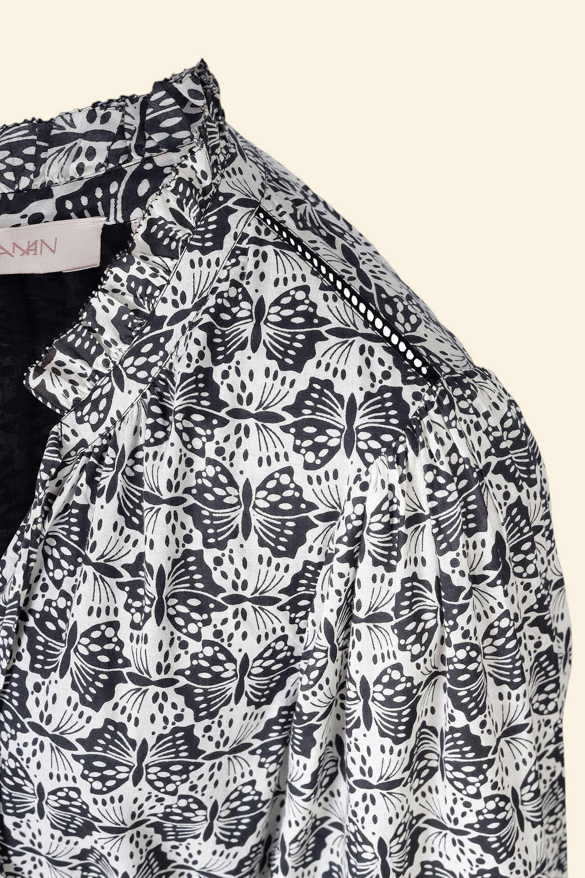 Banjanan Liza dress in black and white cotton voile with a geometric butterfly print, ruffle neck, and lace detail.