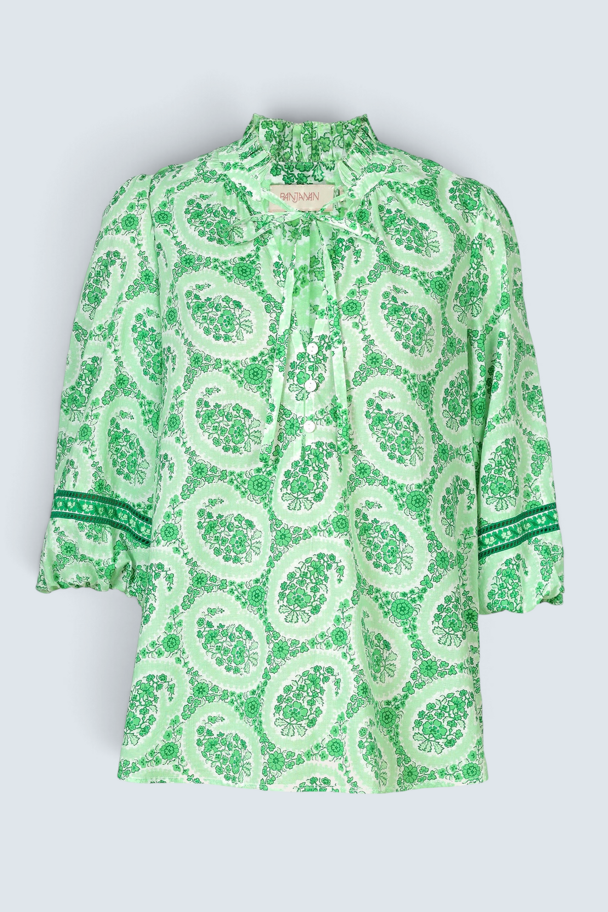 Ghost image of a green paisley Lorna blouse with ruffled tie neckline, button front, and contrast-trimmed sleeves.