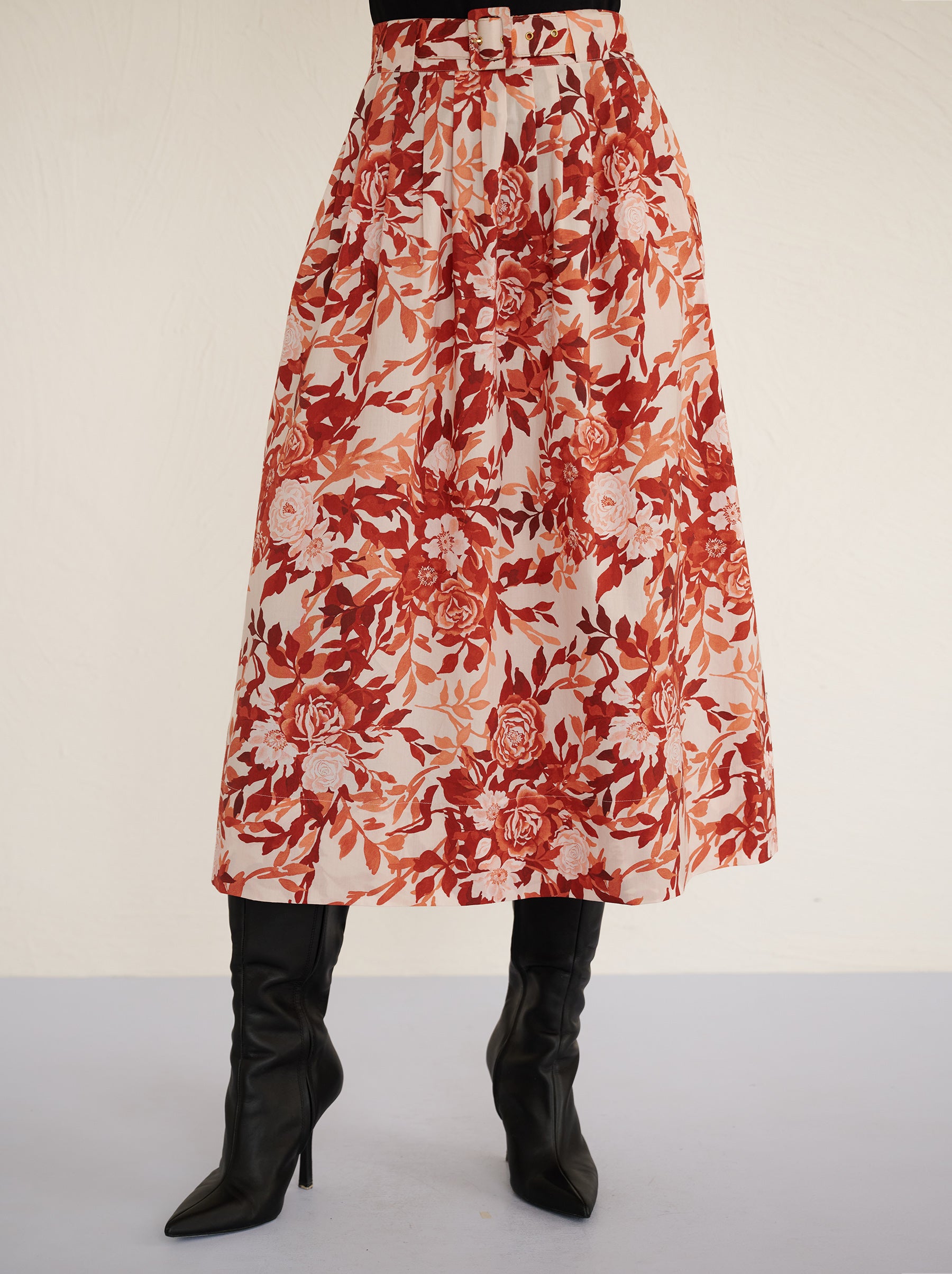 Front view close up of a model standing. She is wearing the Magdalena skirt in the Bibi Rose print. It is featuring soft all-around pleats, side-seam pockets, and a back zipper fastening for a classic, flattering silhouette.