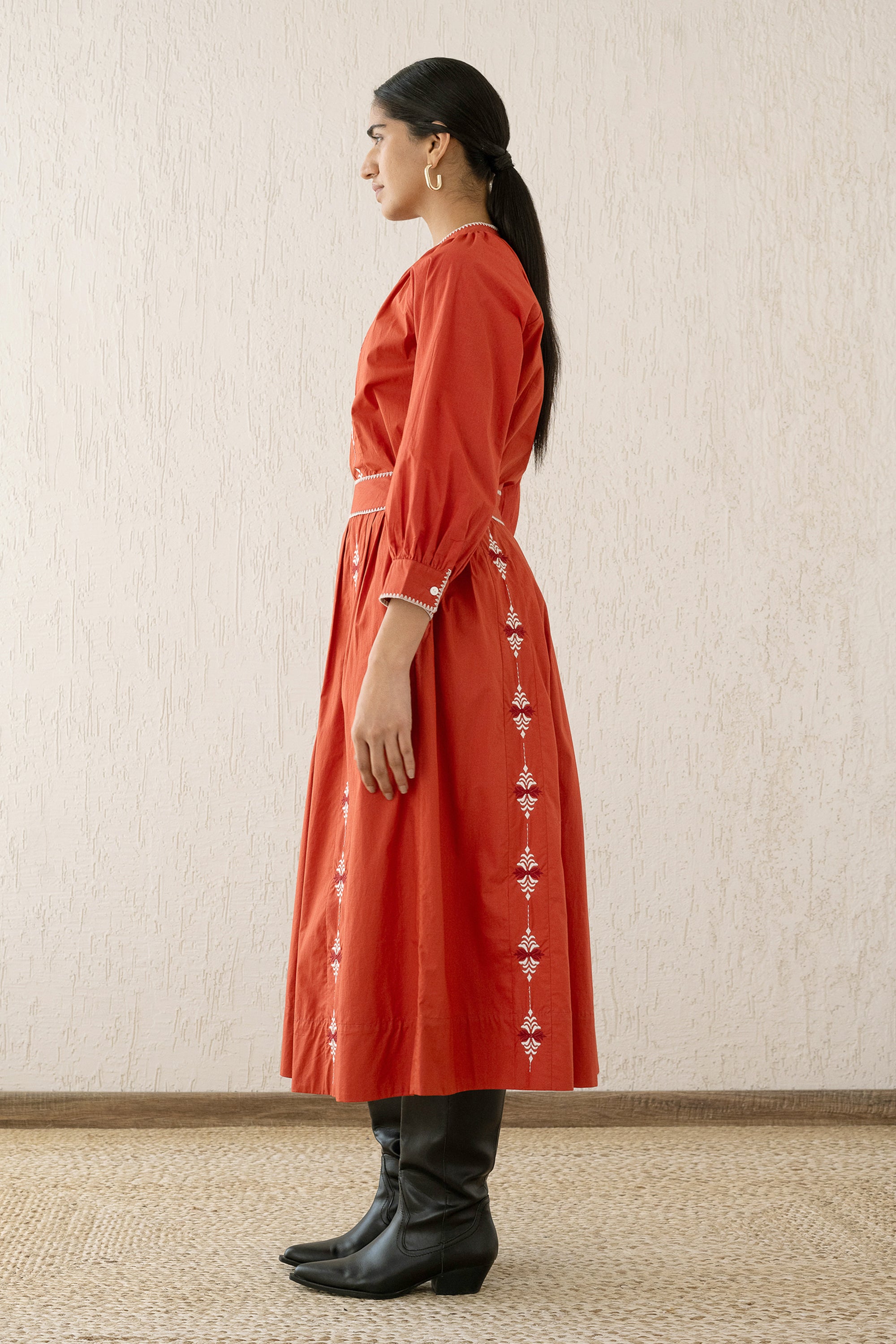 Side view of a woman wearing the Magdalena Skirt Sacher Rooibos, featuring exquisite embroidery inspired by Austrian folk art, side pockets, and a side zipper fastening.