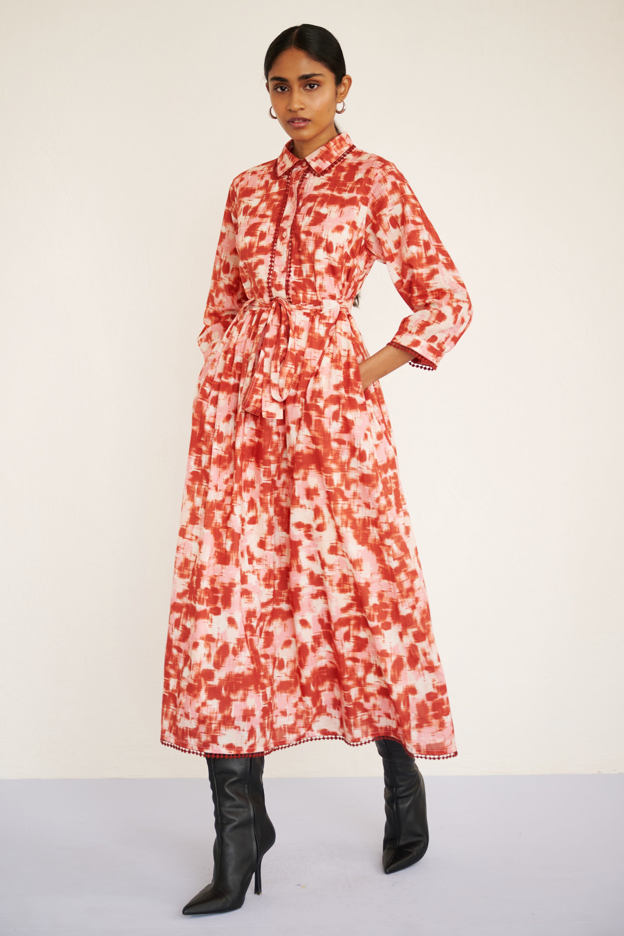 Front view of woman wearing a tailored cotton midi shirtdress with lace trim at the collar, placket, and hem, featuring an ikat-inspired animal print.