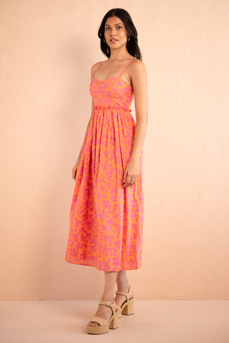 Side view of model posing wearing Phoebe Dress in Gaia Nectarine print.