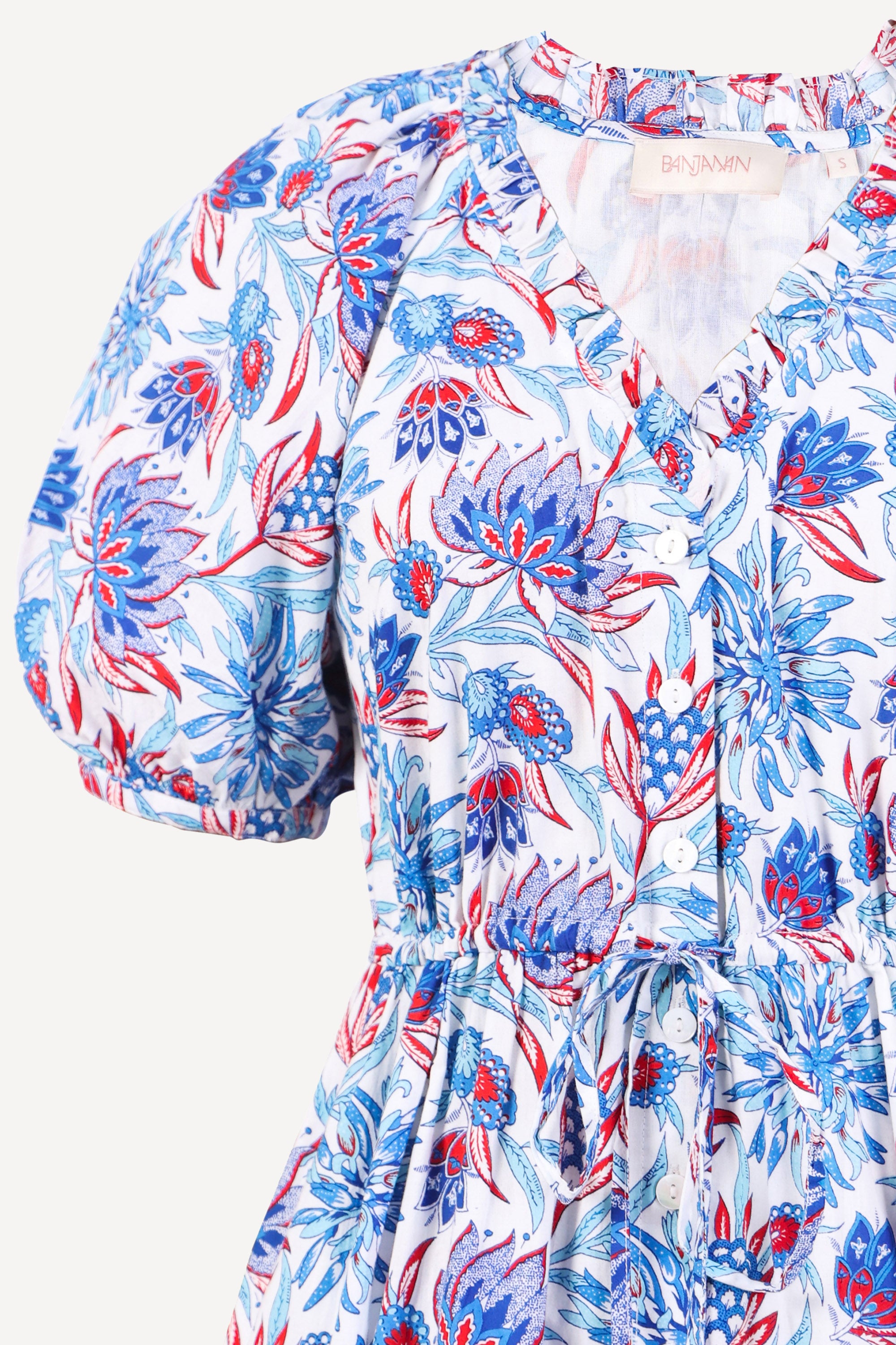Front view close up of the Poppy dress in Philippa floral print with raglan blouson sleeves, button front, drawstring waist, and flowing skirt.