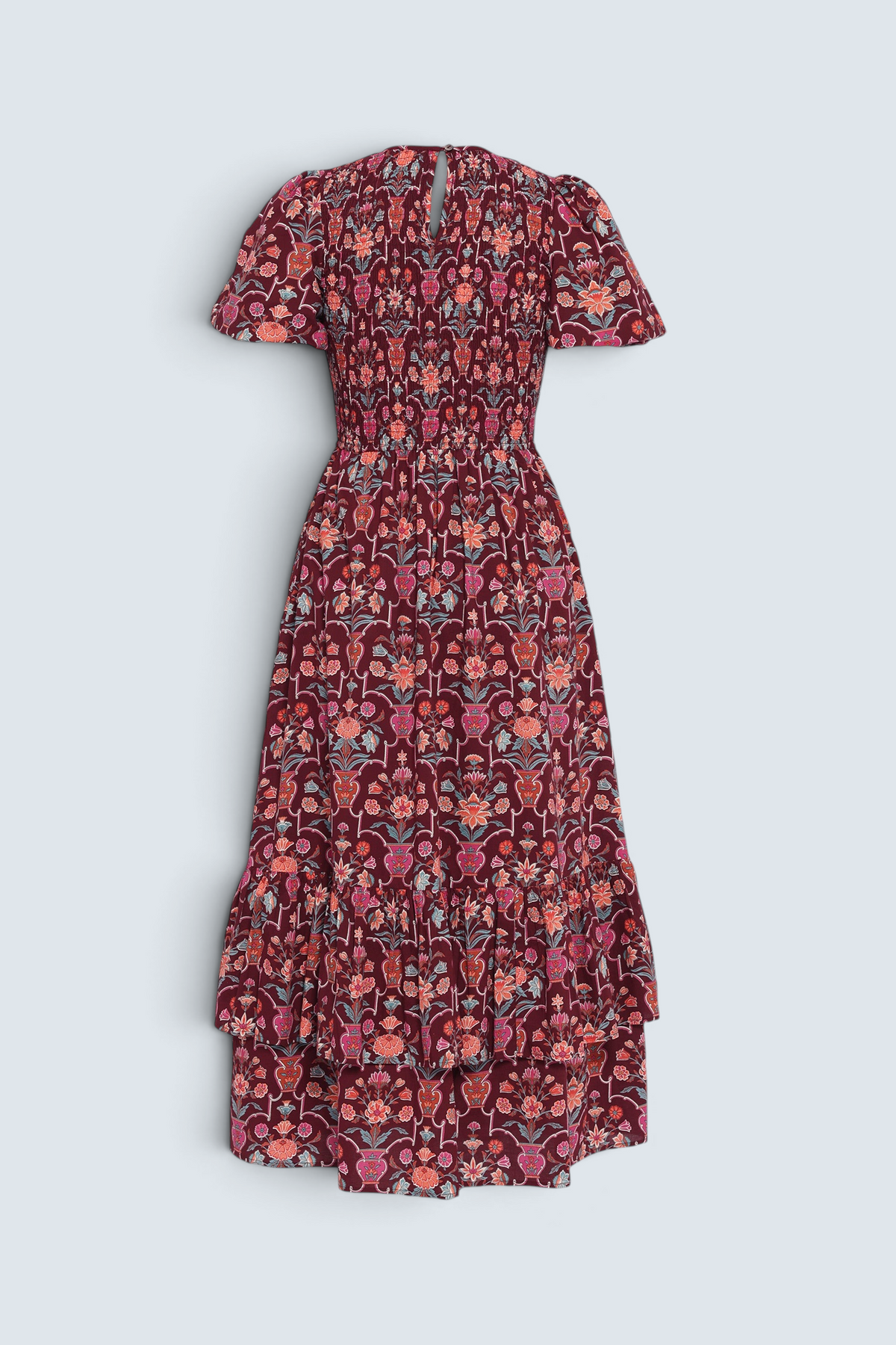 Back view of the Quant dress in Floral Vase print on a white background. It features a smocked bodice, puffed sleeves, and a full tiered skirt with pockets.
