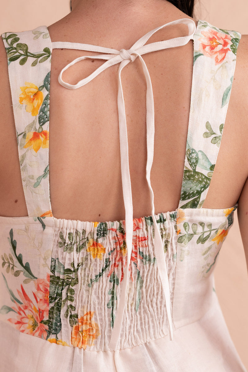 Back view close up of model wearing Ophelia Dress in Desert Rose Dawn print in linen showing drawstring tie and smocking details at back.