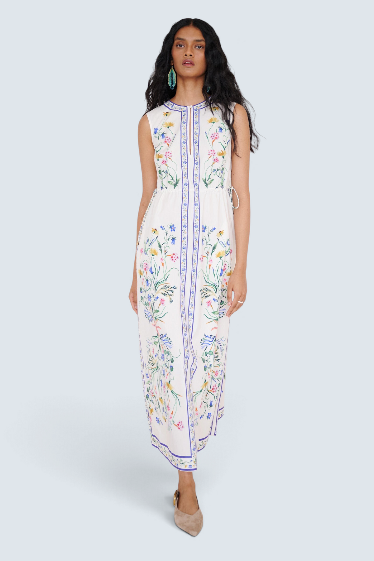 Front view of a woman walking wearing the Rhonda column dress in Tidepool print, featuring side drawstrings with gold caps, front keyhole button, and side-seam pockets.