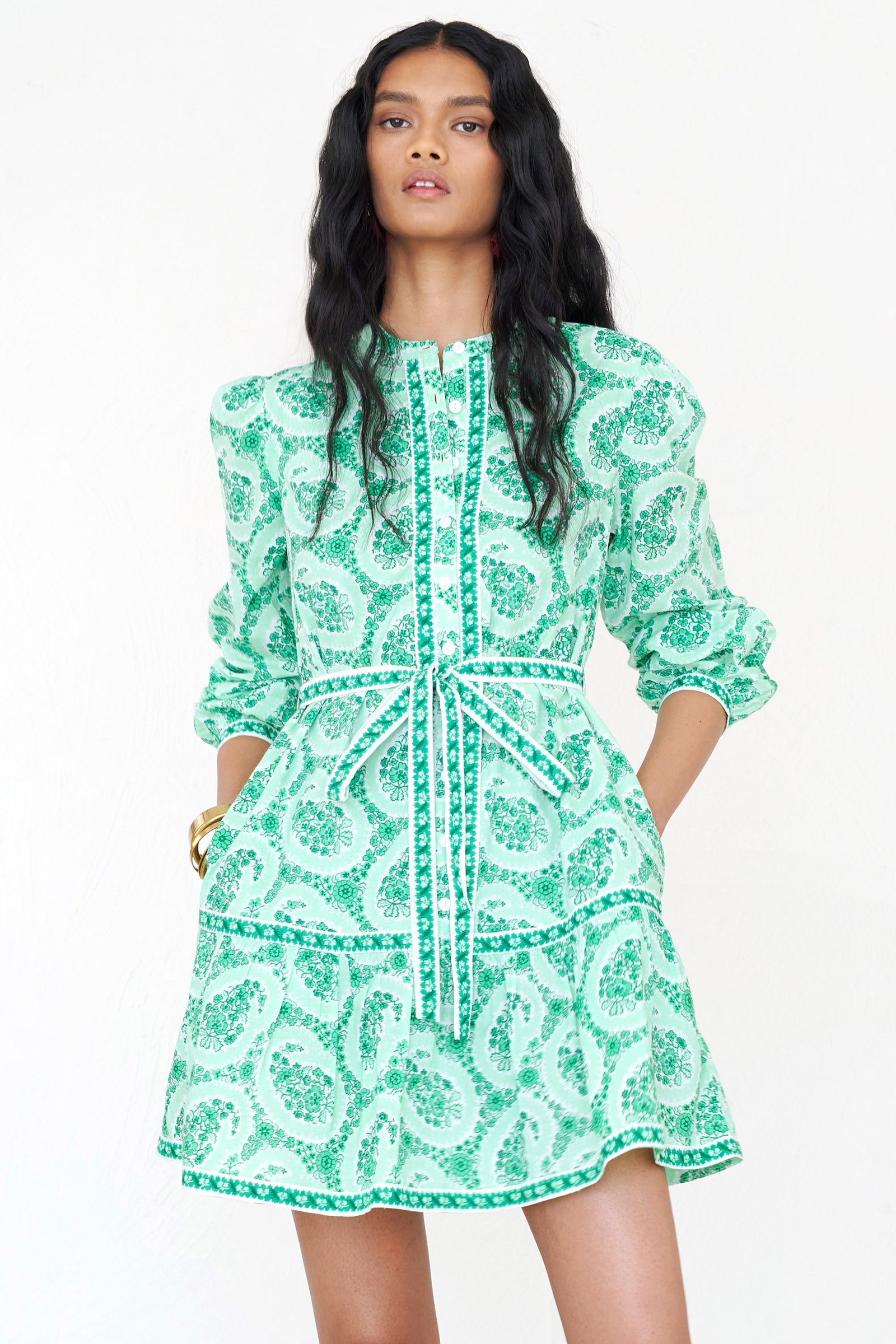 Front view close up of a woman standing. She is  wearing the Roma mini shirtdress in Paisley Copse print, featuring a contrast-trimmed front placket, side seam pockets and detachable belt.