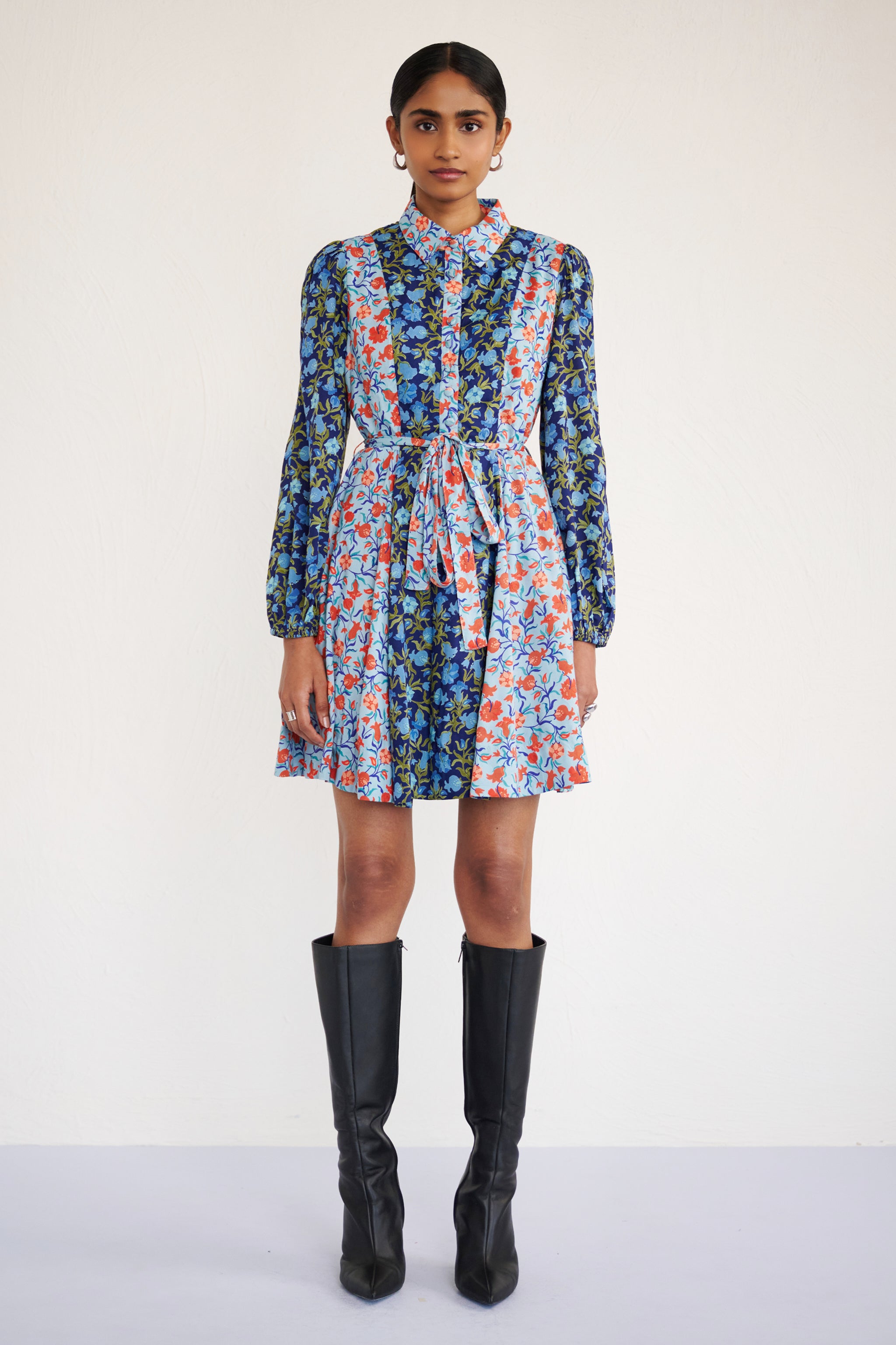 Front view of woman wearing a mini shirtdress with lantern sleeves, a delicate collar, and contrast pomegranate vine print, styled with side pockets.