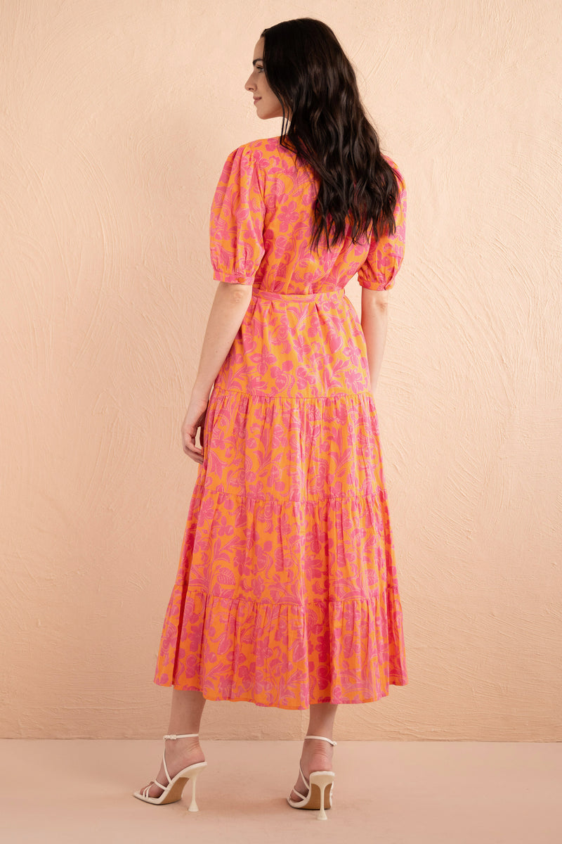 Back view of model wearing a full length Saylor Dress in Gaia Nectarine print.