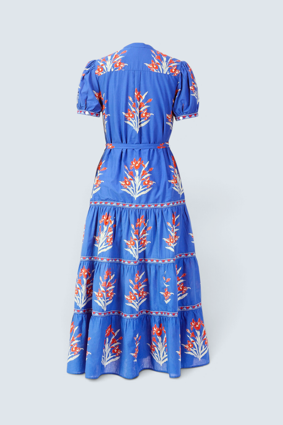 back view of the Saylor dress in Brigitte print. It features a full-length tiered skirt, detachable belt, and classic shirtdress silhouette in hand-screen-printed cotton voile.