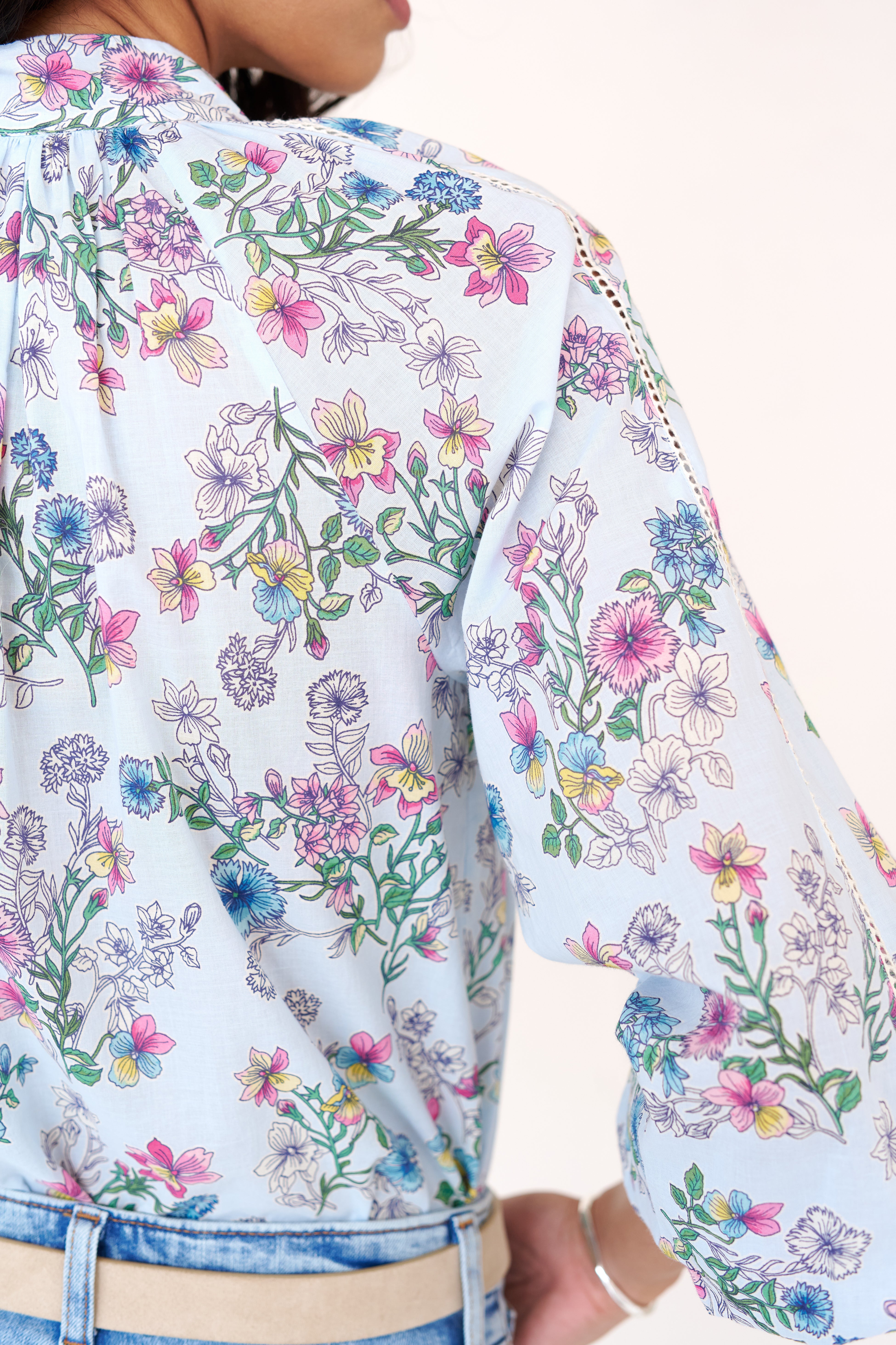 Back view close up of woman wearing the Tara shirt featuring lace trim detailing in the Burdock floral print Imperial color.