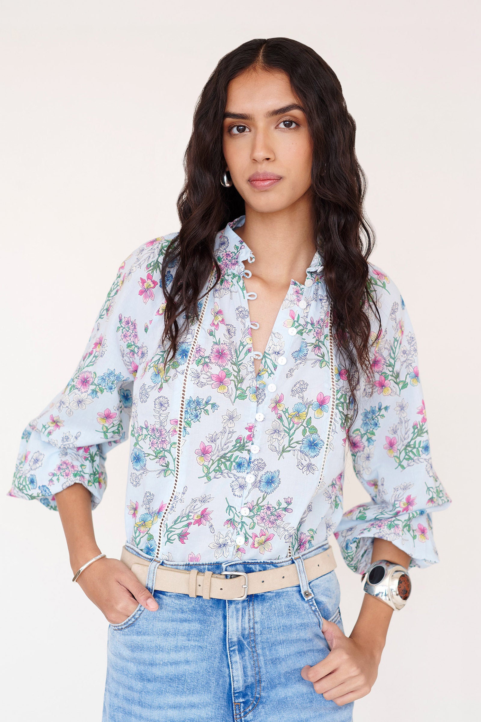 Front view of woman wearing the Tara shirt with a stand collar, elasticated button loops, lace trim detailing, and the Burdock floral print in imperial color.