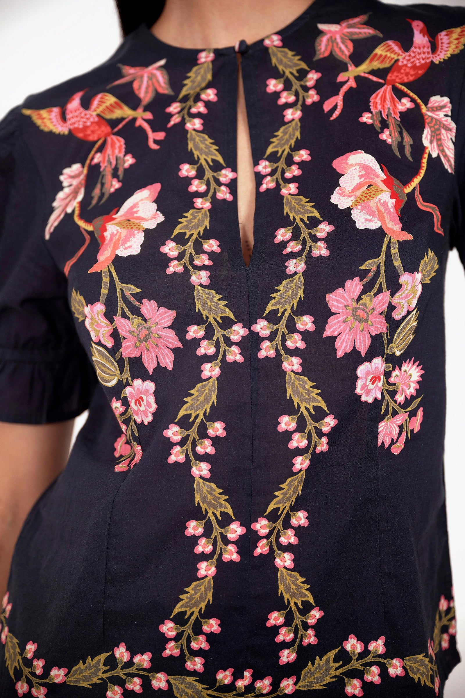 Front view close up of model standing. She is wearing the Ricki top in Chintz print, featuring a crewneck with keyhole detail, adjustable drawstring sleeves, and vintage-inspired print placement.