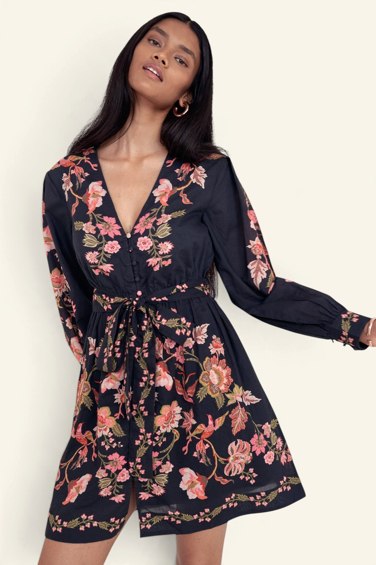 Banjanan Anne mini dress in black cotton voile with a floral Chintz print, long sleeves, and a fabric waist belt.