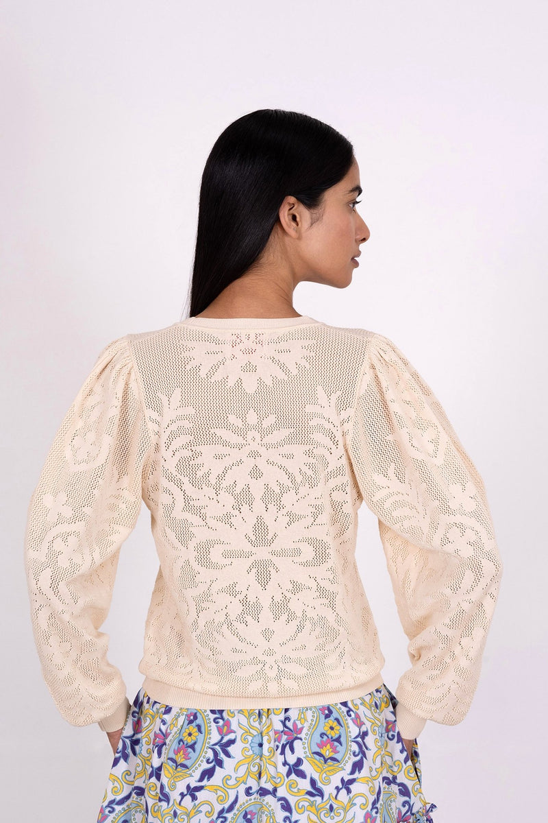 Back view of woman wearing the Astrid Doge's crew neck sweater, a white knit resembling lace. Perfect for transitional weather, it pairs well with skirts or pants.