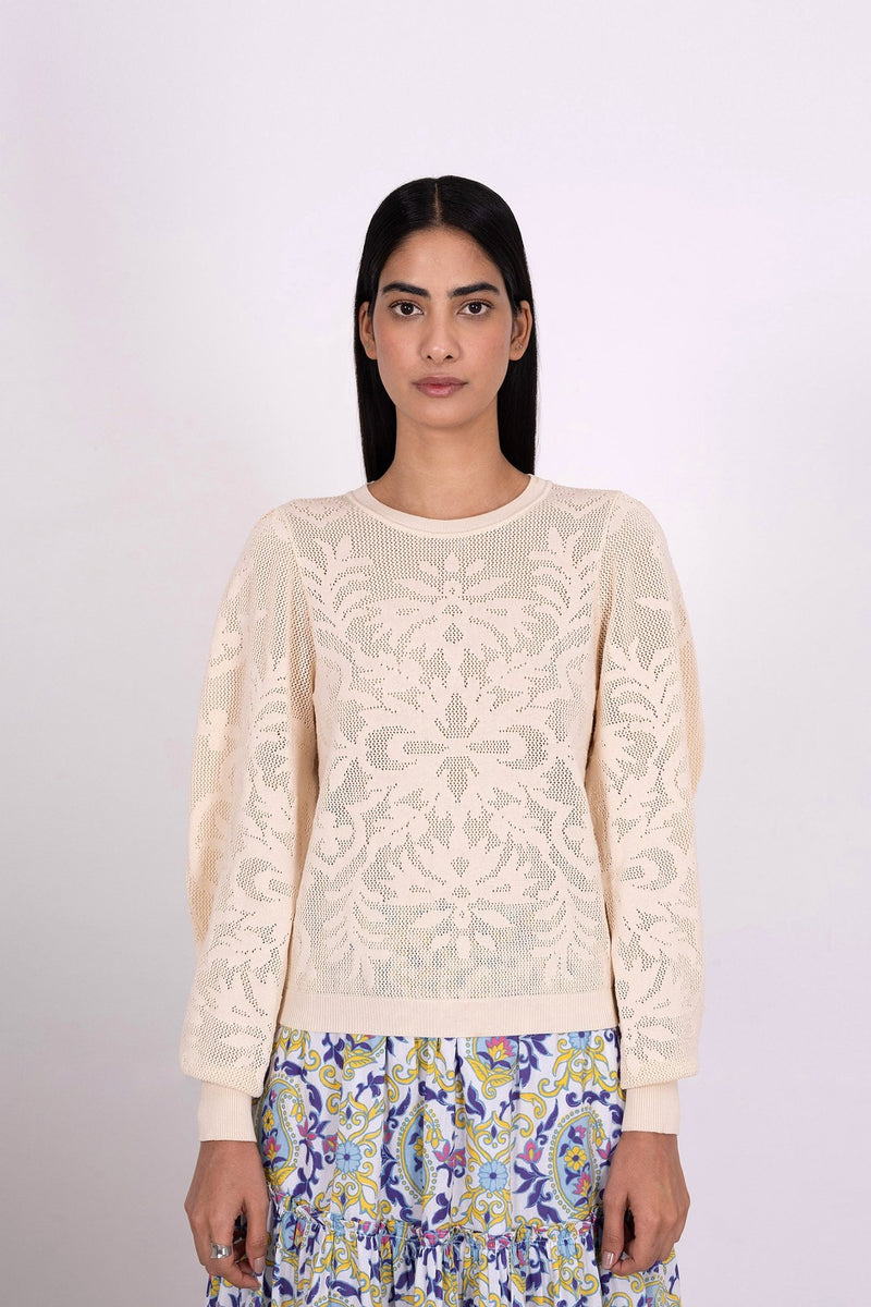 Front view of woman wearing the Astrid Doge's crew neck sweater, a white knit resembling lace. Perfect for transitional weather, it pairs well with skirts or pants.