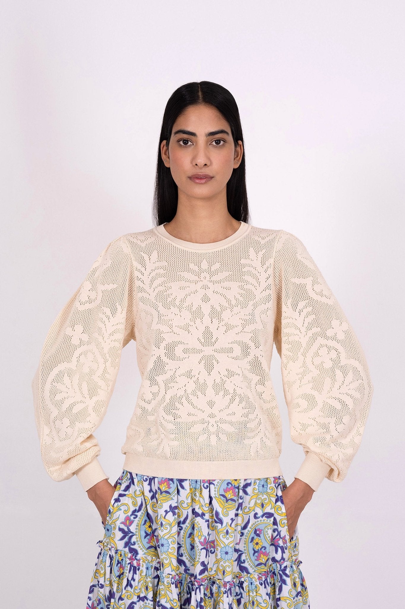 Front view of woman wearing the Astrid Doge's crew neck sweater, a white knit resembling lace. Perfect for transitional weather, it pairs well with skirts or pants.