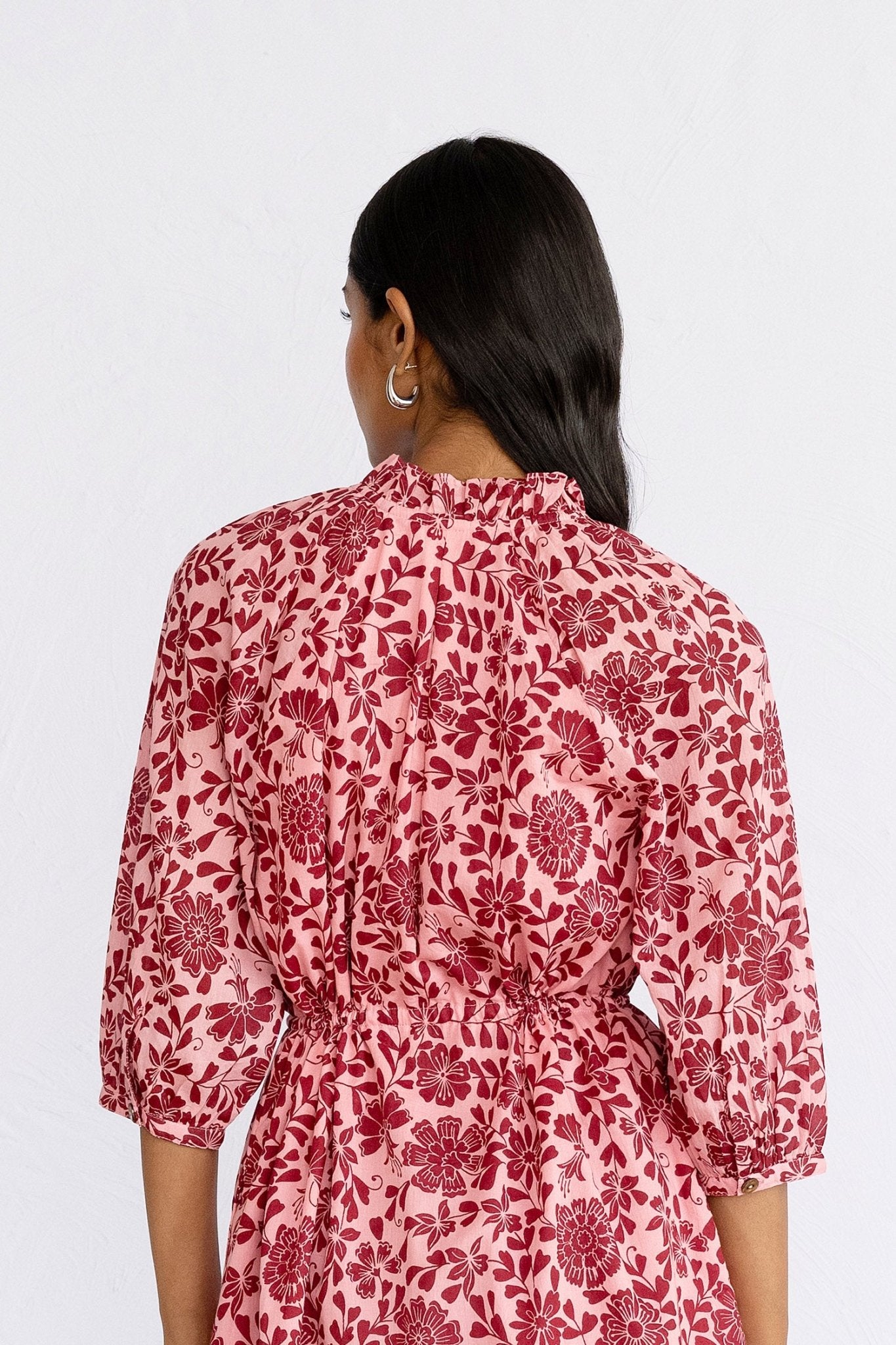 Back view close up of model wearing mini Benita Dress in Komodo Candy print showing neckline and sleeve details.