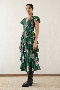 Side view of a woman wearing the Brigit dress in Tartan Rose print. It features a cascading skirt of tiered ruffles, pin tucks under bust and waist, a V-neck, and cap sleeves.