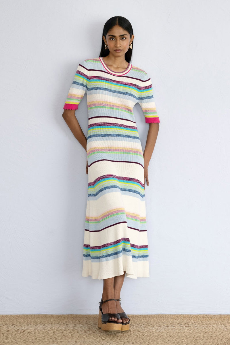 Front view of model posing on a wall wearing Calla Dress Opal Ombre.