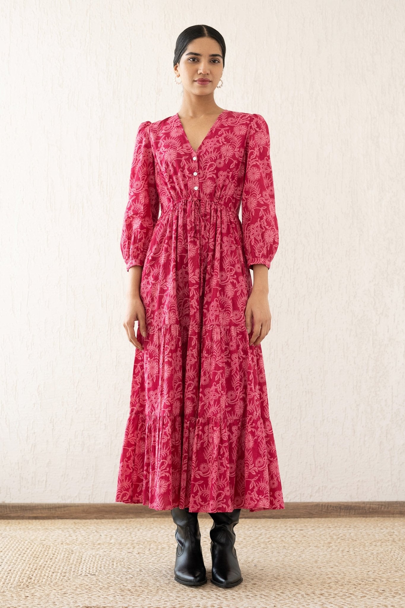 Front view of a woman wearing the Castor dress with soft puff sleeves and a gathered drawstring skirt in Tresse Winterberry print, a floral design. The dress is fully lined finished with side seam pockets.