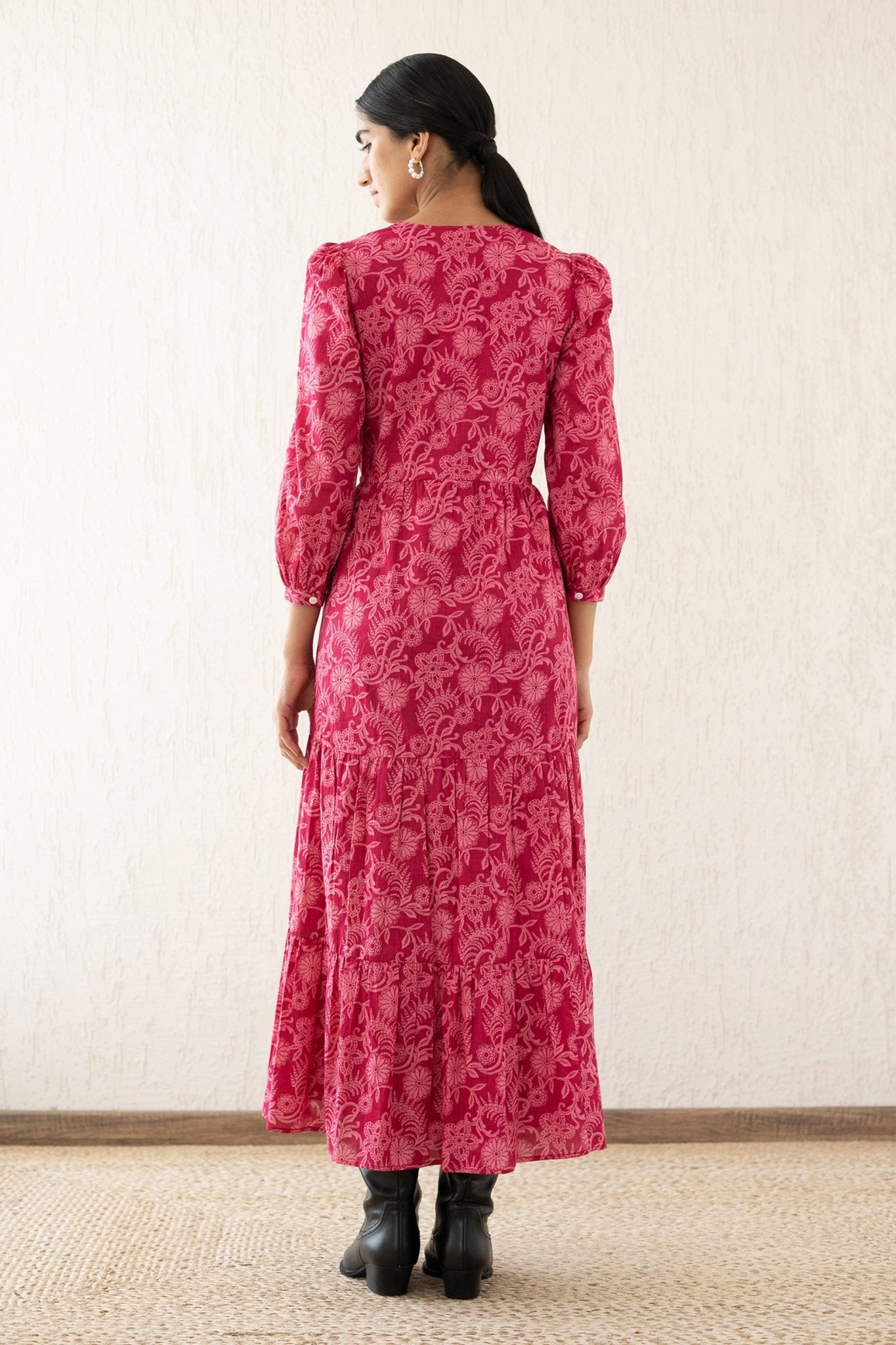 Back view of a woman wearing the Castor dress with soft puff sleeves and a gathered drawstring skirt in Tresse Winterberry print, a floral design. The dress is fully lined finished with side seam pockets.