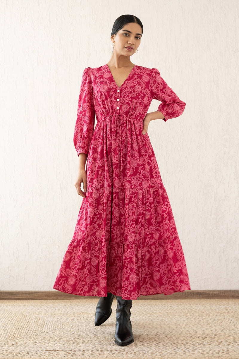 Front view of a woman wearing the Castor dress with soft puff sleeves and a gathered drawstring skirt in Tresse Winterberry print, a floral design. The dress is fully lined finished with side seam pockets.