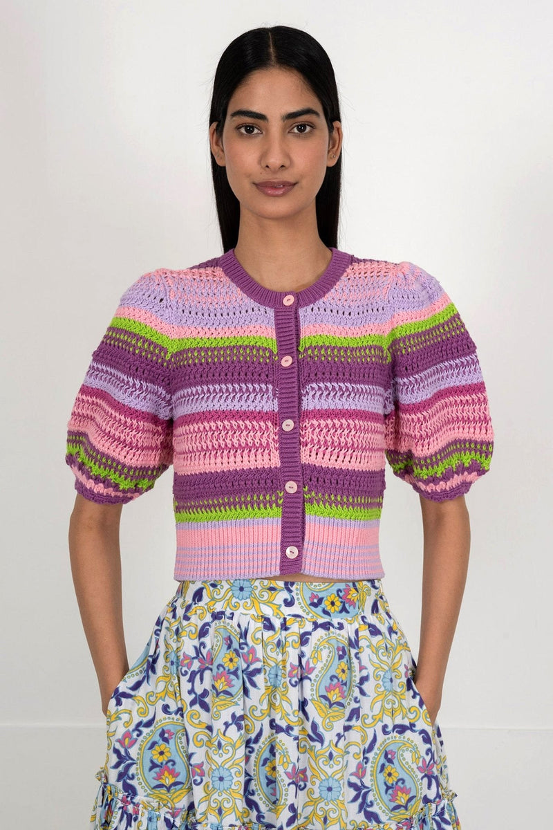 Front view of woman wearing the Celeste cardigan, a hand-crocheted piece in vibrant colors inspired by minerals. Perfect for layering over dresses or pairing with pants.