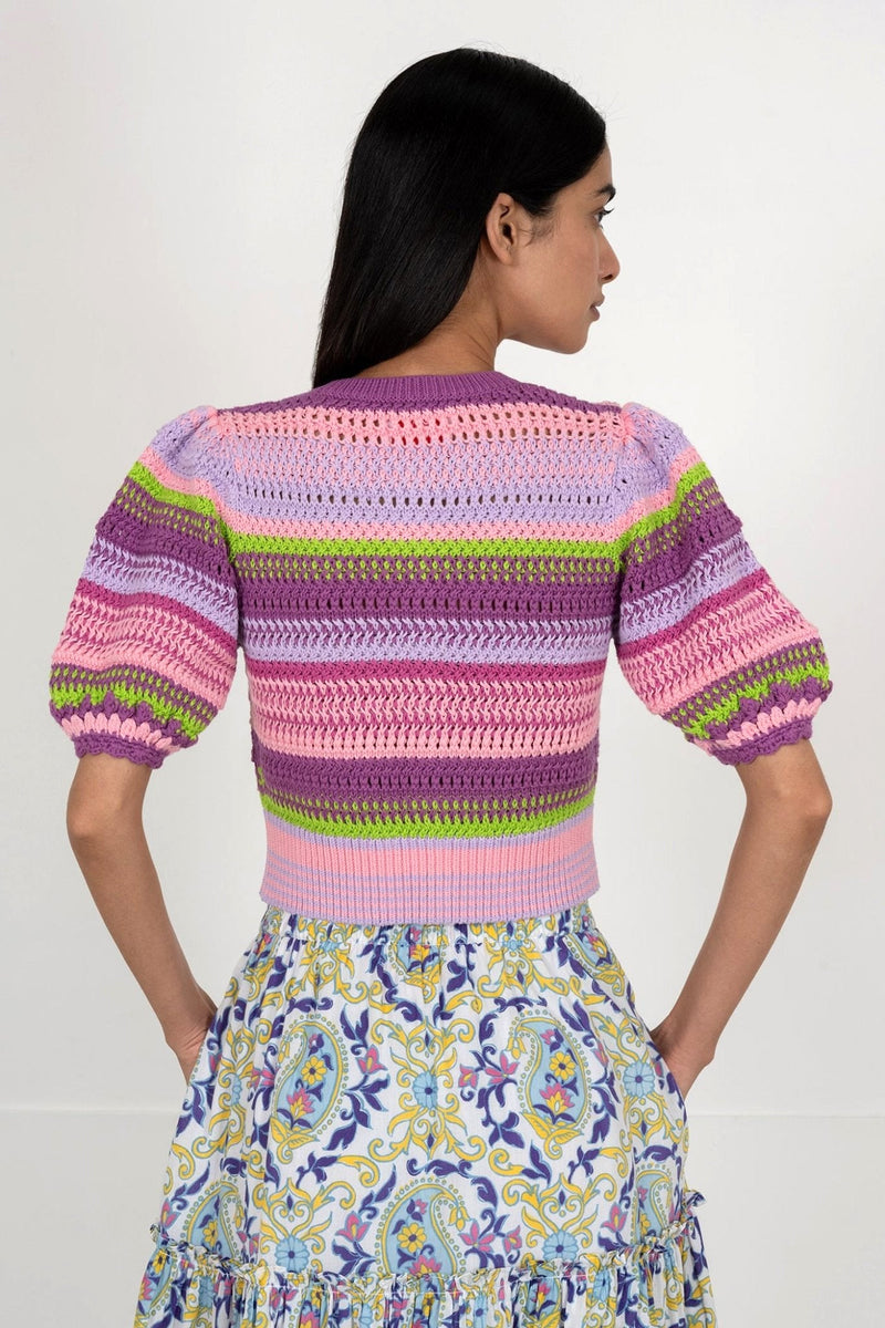 Back view of woman wearing the Celeste cardigan, a hand-crocheted piece in vibrant colors inspired by minerals. Perfect for layering over dresses or pairing with pants.