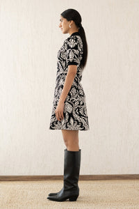 Side view of woman wearing the best-selling Elise dress, featuring a soft A-line cut and stretchy knit, inspired by vintage lace and embroidery. Perfect for fall.