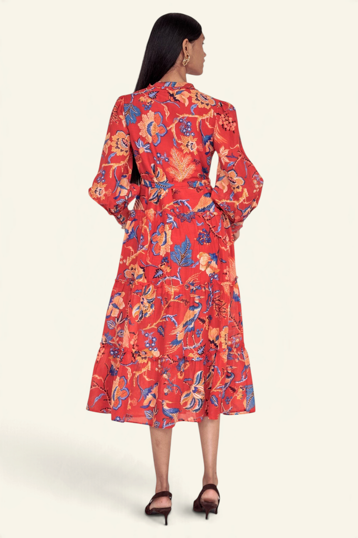 Banjanan Emira dress in carmine red cotton silk with a floral chintz print, tiered skirt, and long sleeves.