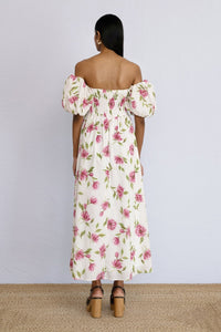 A back view of model standing wearing an off shoulder styled Farida Dress Killara Syrath.