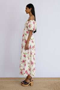 A side view of model standing wearing an off shoulder styled Farida Dress Killara Syrath.