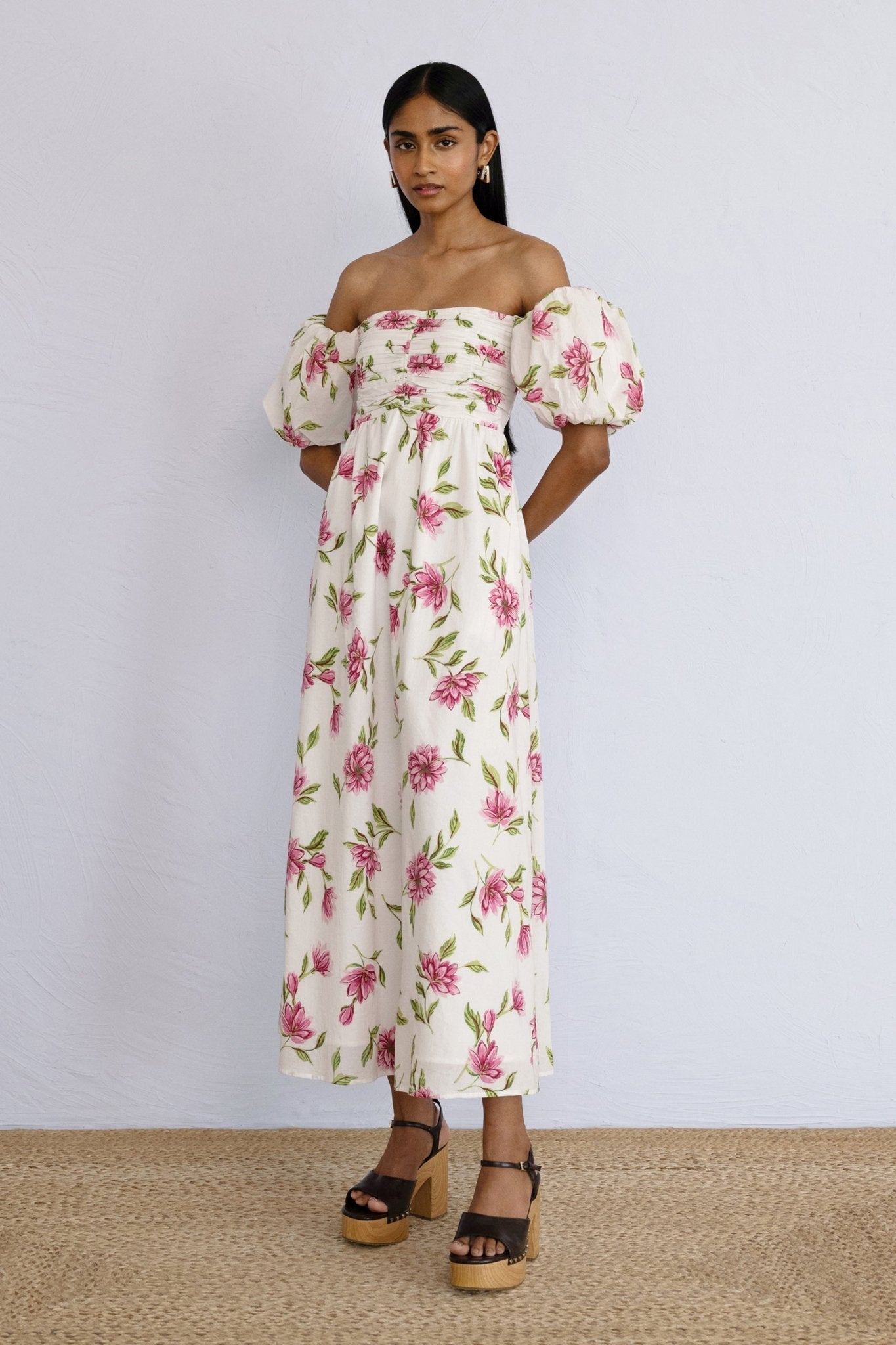 A front view of model psoing wearing an off shoulder styled Farida Dress Killara Syrath.