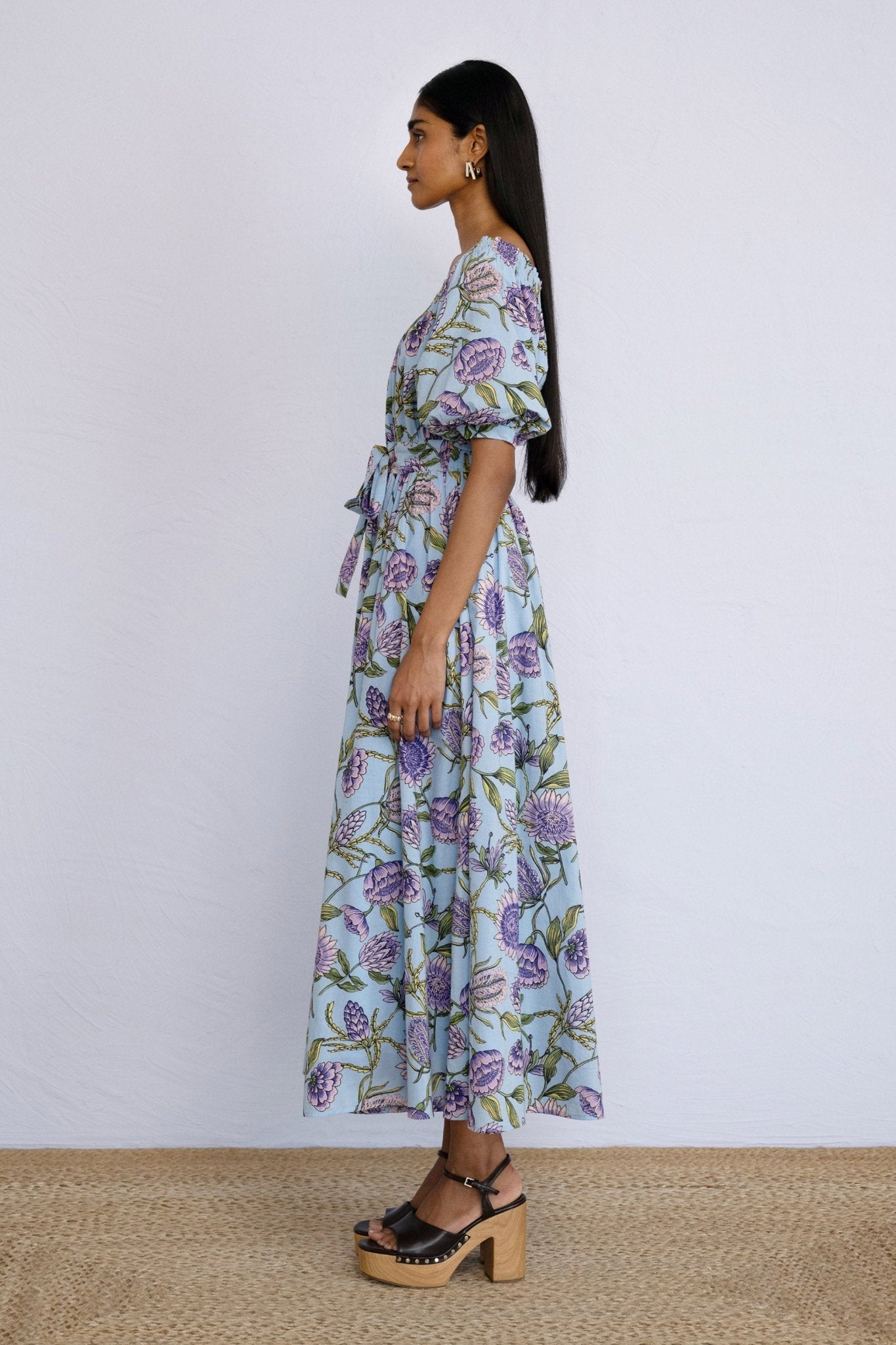 Side view of model standing straight wearing Heidi Dress in Protea Orchid print.