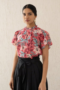 Close-up front view of a woman wearing the Joyful top with tucked raglan sleeves and a buttoned keyhole at the back, showcasing the bold Elisabetta Vine Rose print.