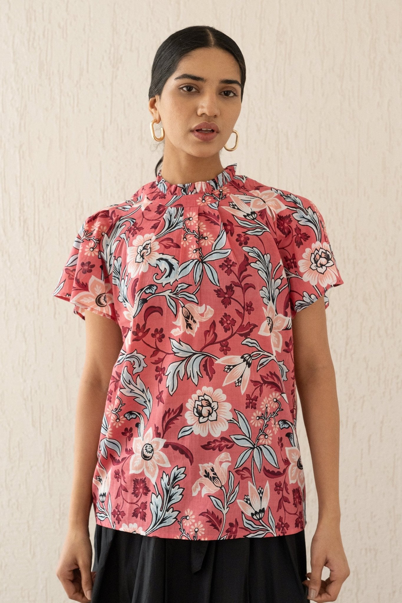 Close-up front view of a woman wearing the Joyful top with tucked raglan sleeves and a buttoned keyhole at the back, showcasing the bold Elisabetta Vine Rose print.