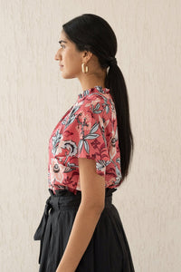 Close-up side view of a woman wearing the Joyful top with tucked raglan sleeves and a buttoned keyhole at the back, showcasing the bold Elisabetta Vine Rose print.