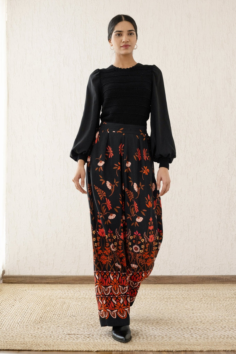 Woman stepping forward wearing Killian Pant, a drapey trousers in Blumen Cedar print, featuring a fluid leg, front darts, and a drawstring waist with elastic for comfort.