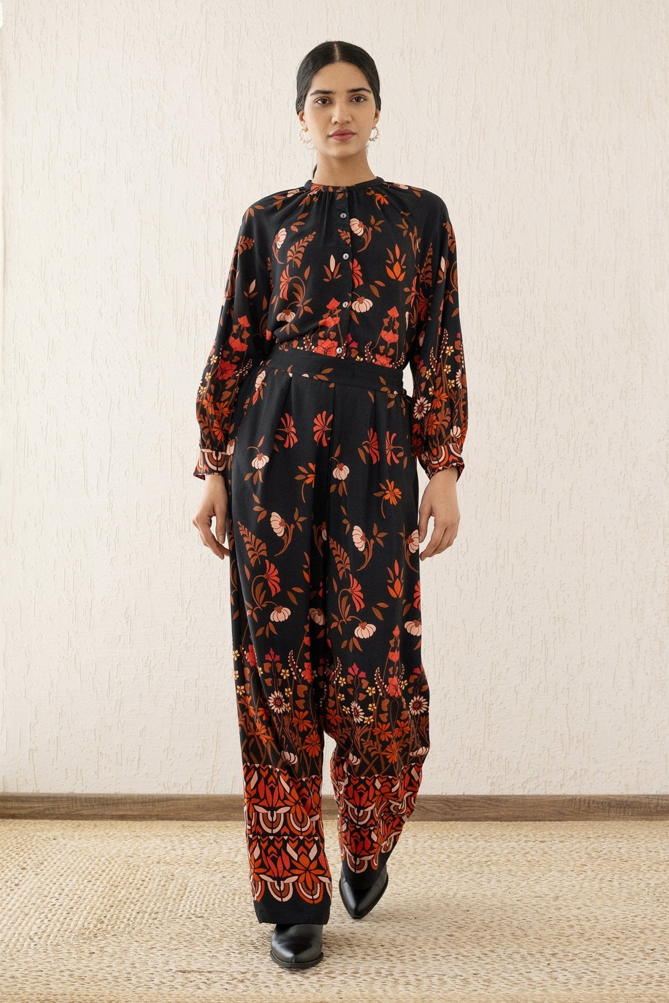 Woman stepping forward wearing Killian Pant, a drapey trousers in Blumen Cedar print, featuring a fluid leg, front darts, and a drawstring waist with elastic for comfort.