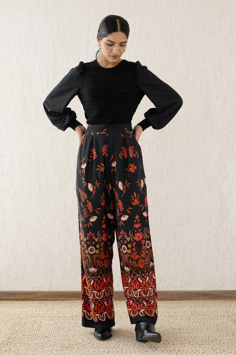 Front view of a woman wearing Killian Pant, a drapey trousers in Blumen Cedar print, featuring a fluid leg, front darts, and a drawstring waist with elastic for comfort.