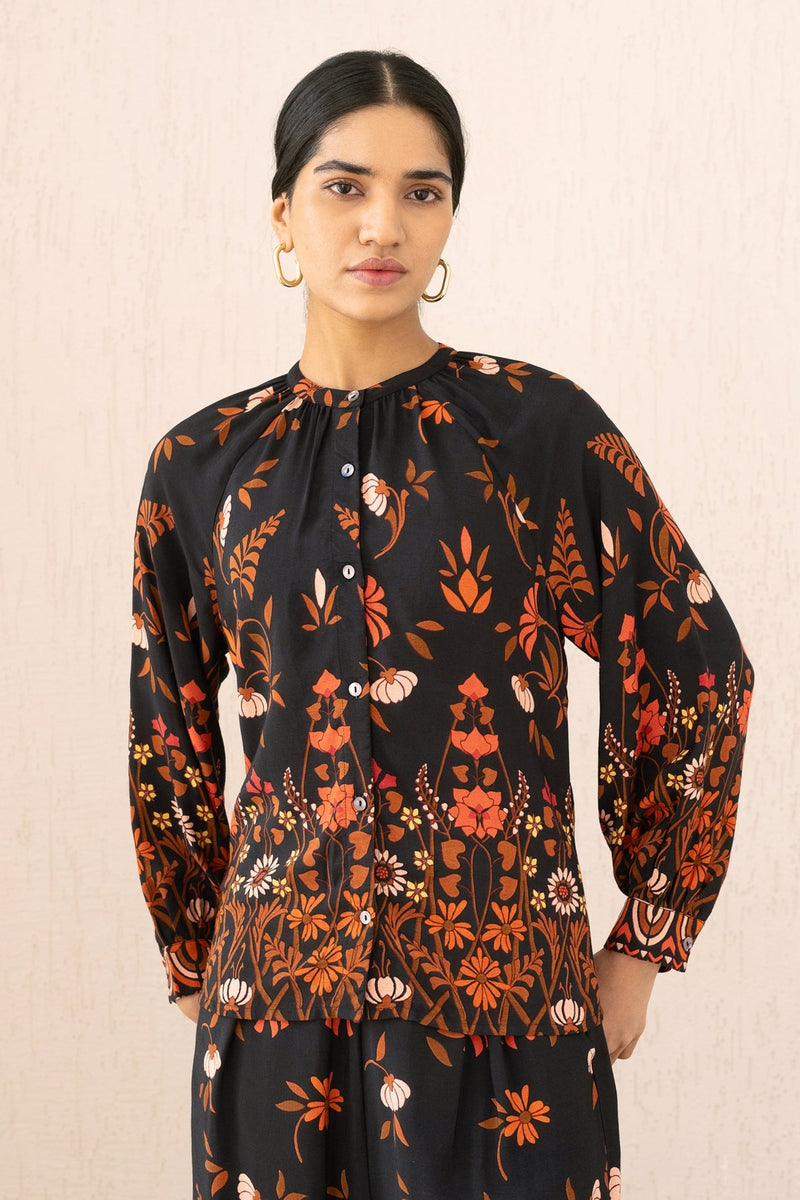 Close-up front view of a woman wearing the Leonie top in Blumen Cedar print, featuring soft gathers at the Mandarin collar and 3/4 raglan sleeves for a flattering drape.