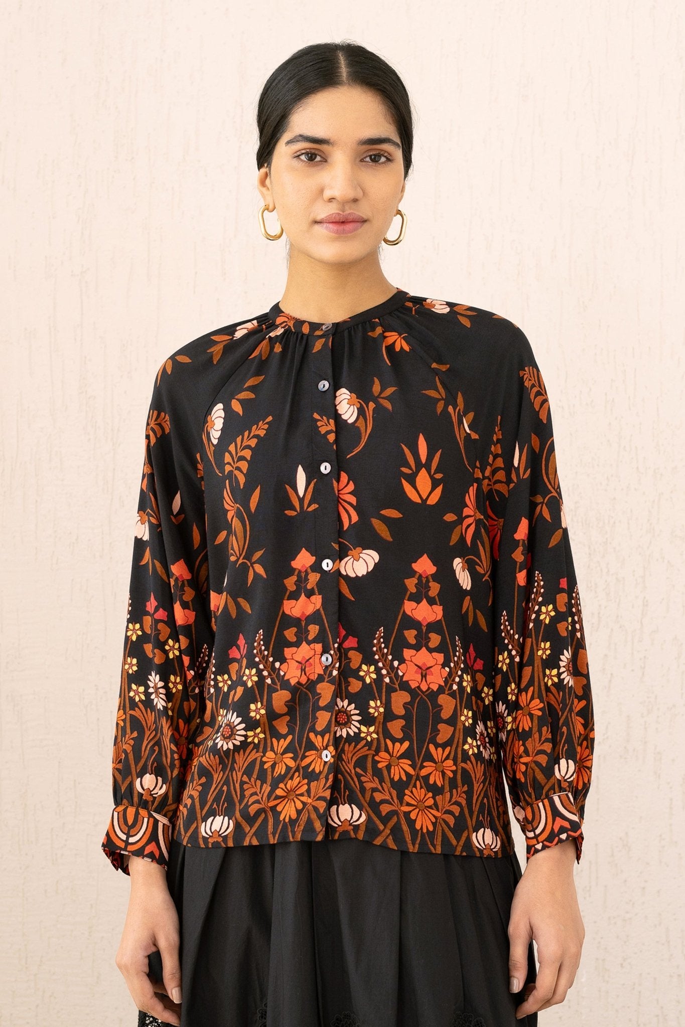 Close-up front view of a woman wearing the Leonie top in Blumen Cedar print, featuring soft gathers at the Mandarin collar and 3/4 raglan sleeves for a flattering drape.