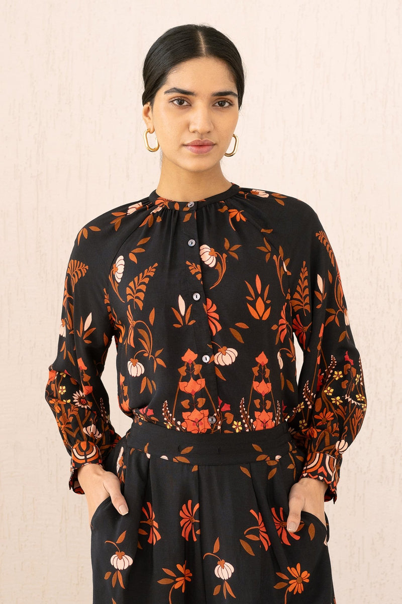 Close-up front view of a woman wearing the Leonie top in Blumen Cedar print, featuring soft gathers at the Mandarin collar and 3/4 raglan sleeves for a flattering drape.