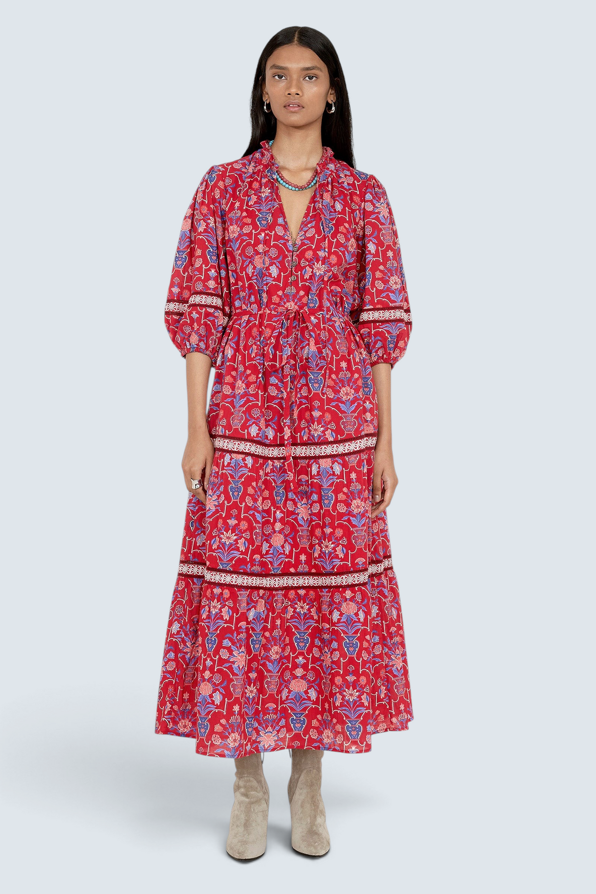 Front view of model standing. She is wearing the Liza dress in Floral Vase print. It features a tie neckline, soft ruffles, lace sleeve and skirt details, and a fabric belt.