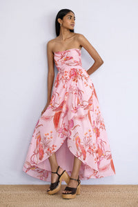 Model posing on the wall standing wearing strapless Madison Dress in Botany Bay Pink Mist print.