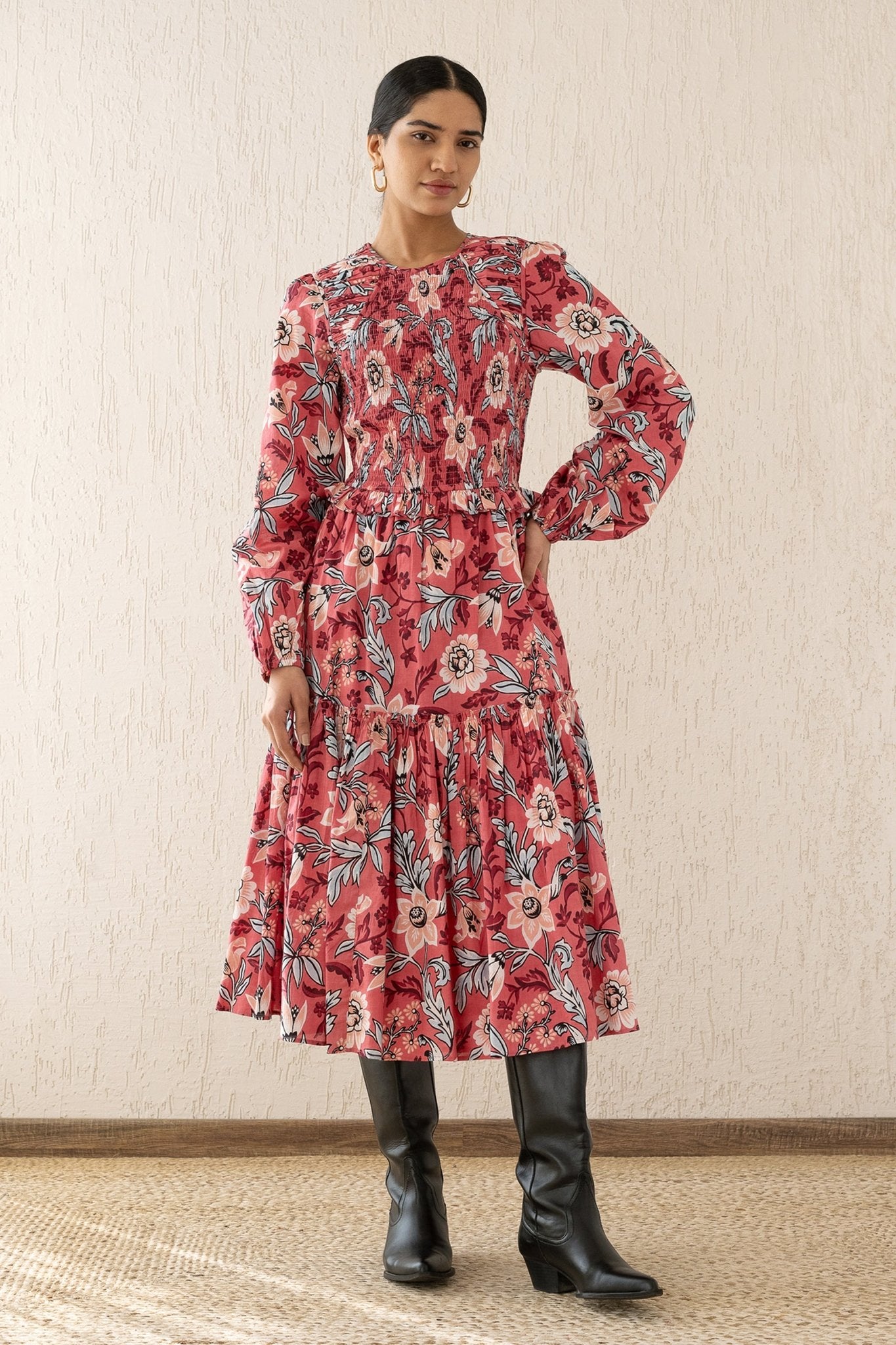 Front view of a woman wearing the Mortiz dress with smocked detailing, ruching at the shoulders, a tiered skirt, and frilled sleeves in Elisabetta Vine Rose print.