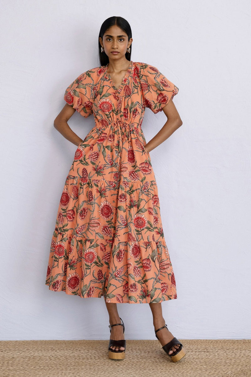 Front view of model posing wearing a Poppy Dress in Protea Crabapple.