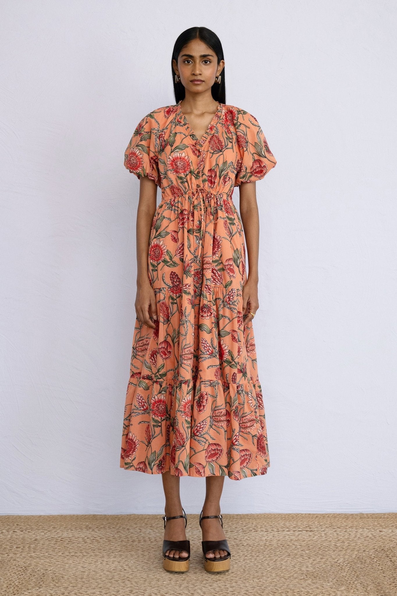 Front view of model wearing a calf length Poppy Dress in Protea Crabapple print.