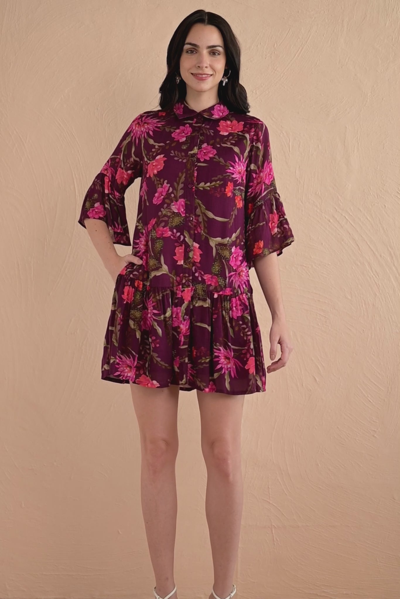 Video of woman wearing Hydra Mini Dress in Desert Rose Dusk print, featuring a button placket, bell sleeves, slightly dropped waist, and side-seam pockets in lightweight viscose voile.
